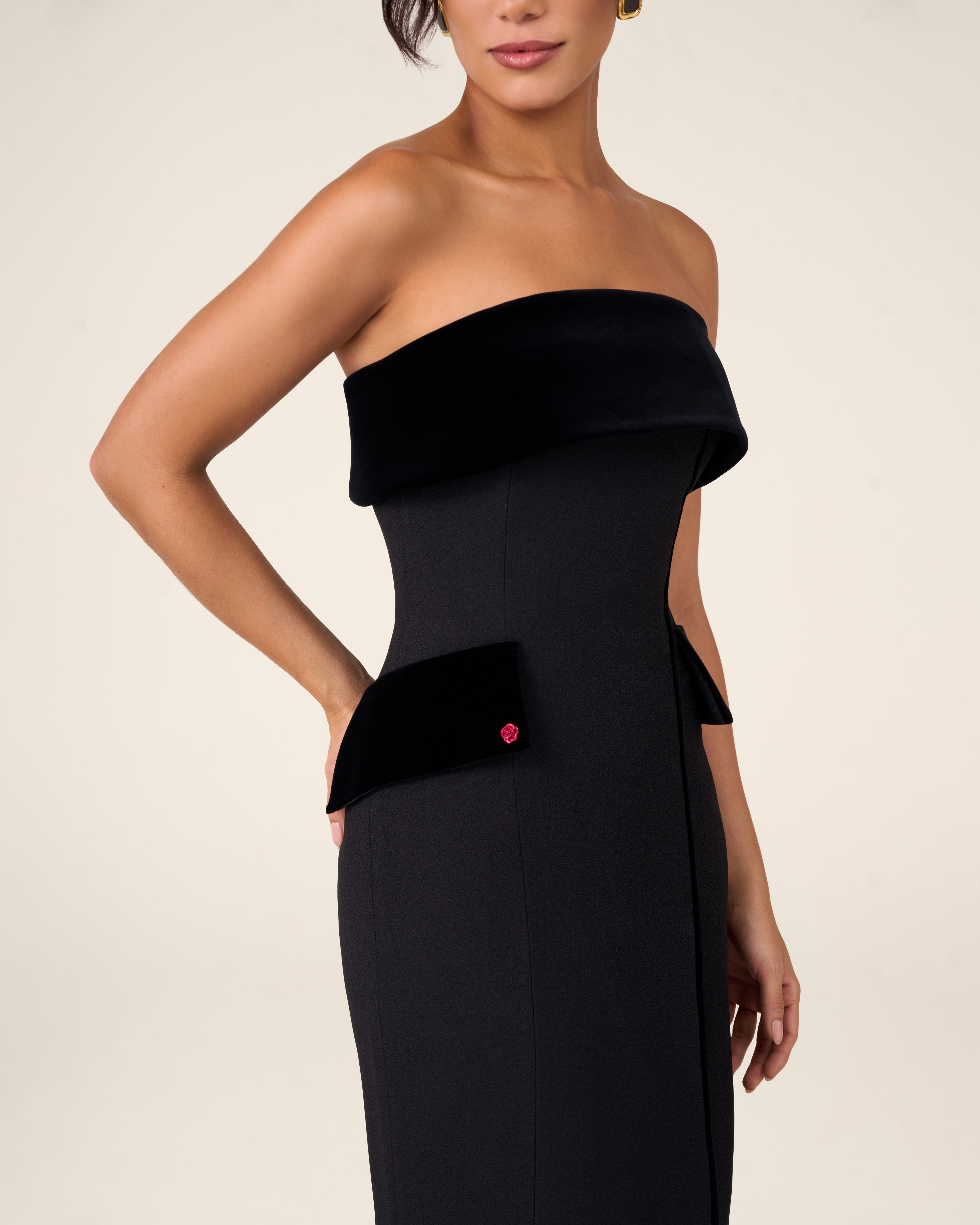 Black bustier dress with wide velvet draping across the chest